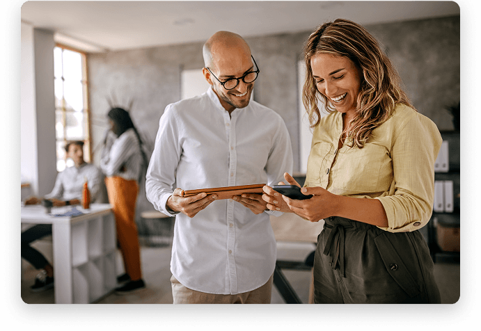Two colleagues reviewing a mobile device during planning and research