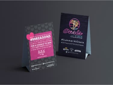 Printed table signage with heart-themed Valentine’s Day contest and #SummerAtOasis coaster-style summer promo for in-venue guests