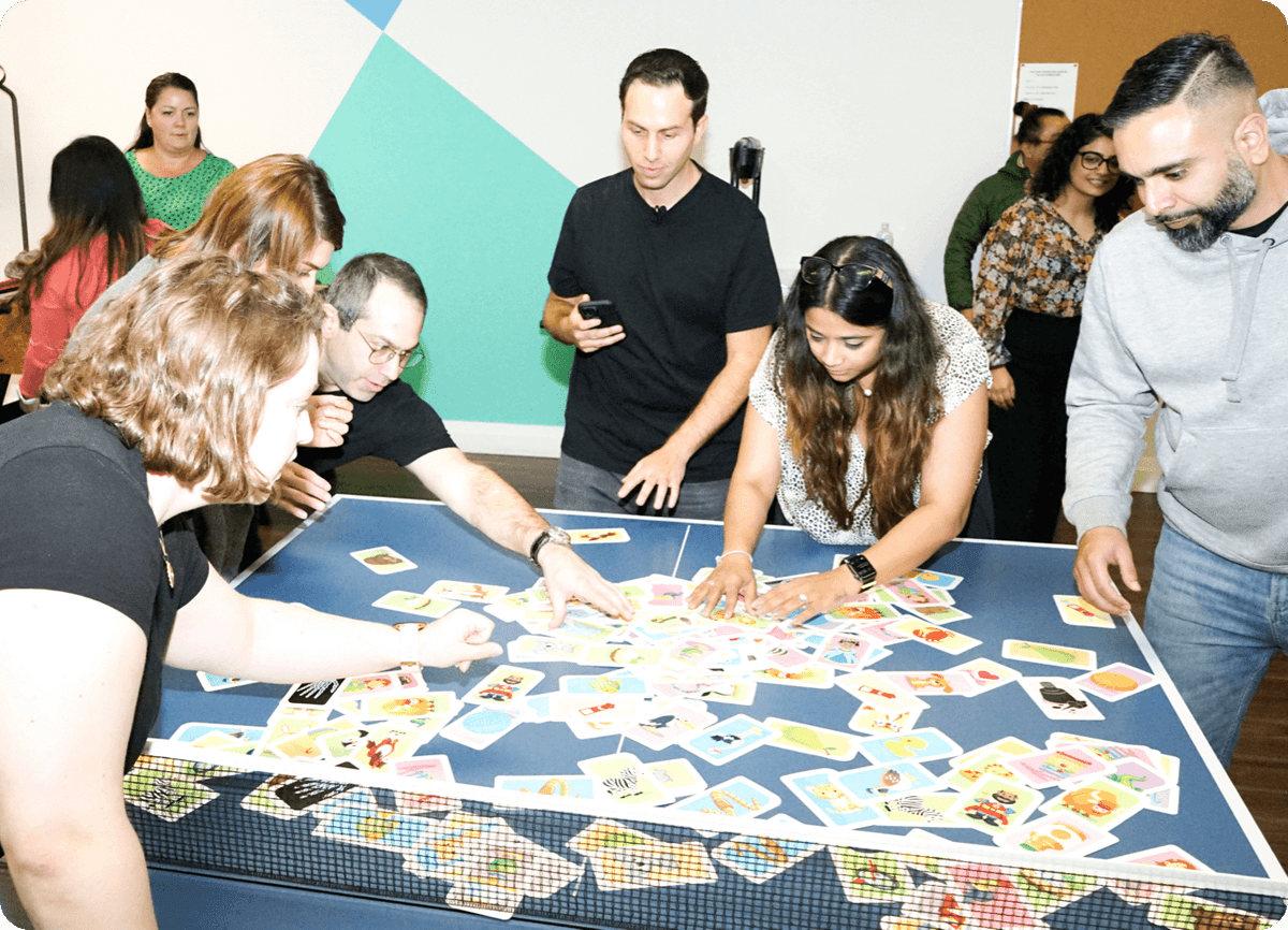 A group of people standing around a table playing a game.