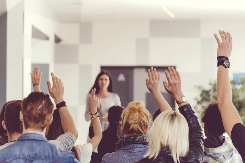 Students raising hands in a classroom seminar