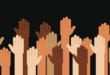 Multi-racial hands raised for anti-racism