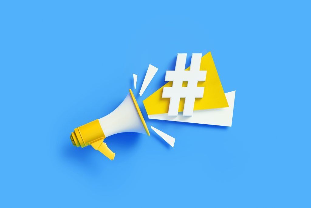 Hashtag symbol coming out from a yellow megaphone on blue background