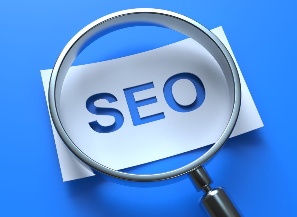 Magnifying glass showing with Search Engine Optimization on paper
