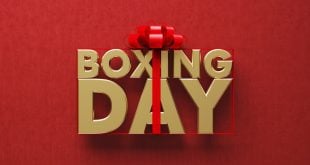 Gold coloured Boxing Day word wrapped by red ribbon on red background.