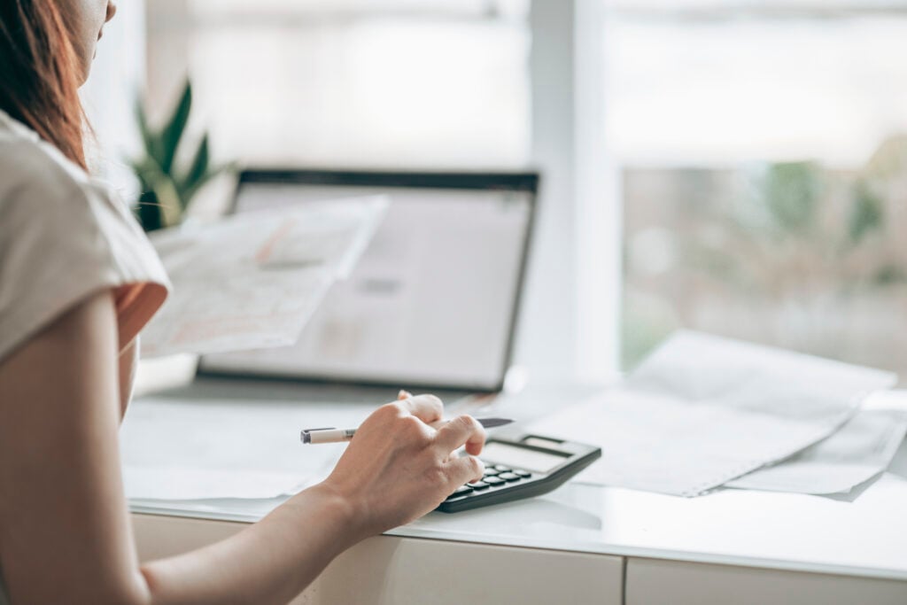 "Calculator and digital ad budget report on a desk, representing the adjustments needed for the new Google Ads surcharge.