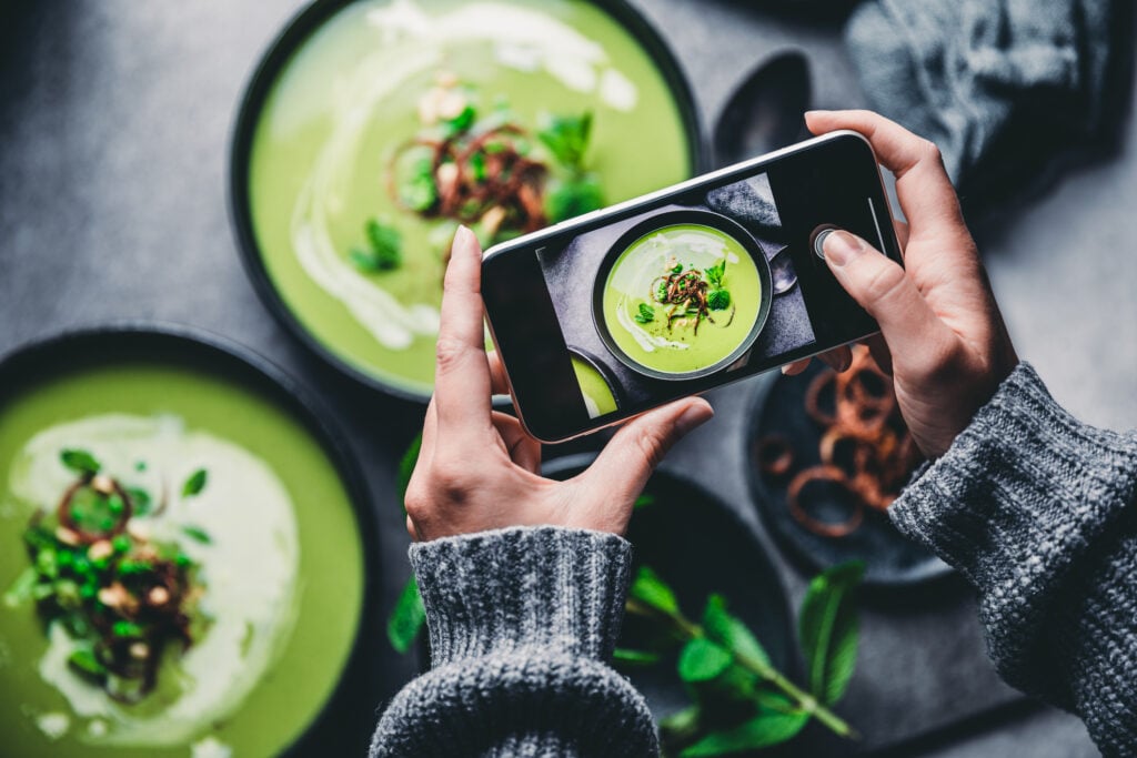 Brand manager holding phone taking a picture of nicely presented food