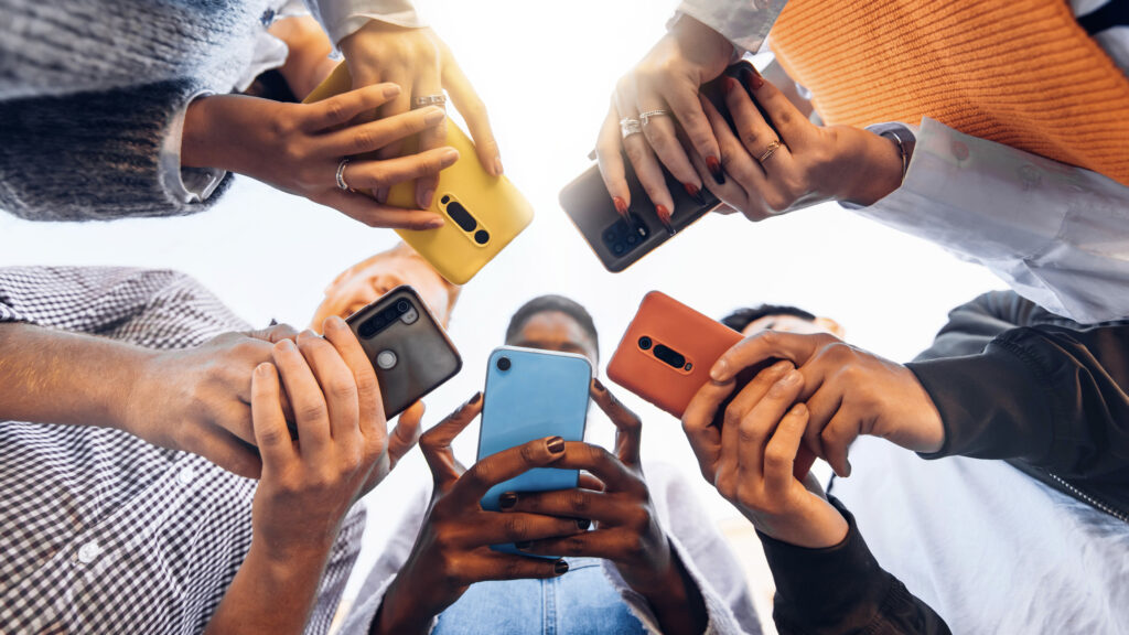 A group of people holding their mobile phones. 