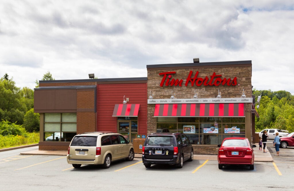 Tim Hortons restaurant during the day in Halifax Canada. People and traffic can be seen outside the brand's restaurant.