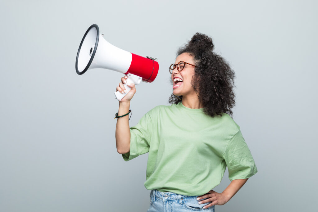 Woman in digital marketing holding a megaphone and speaking into it. 