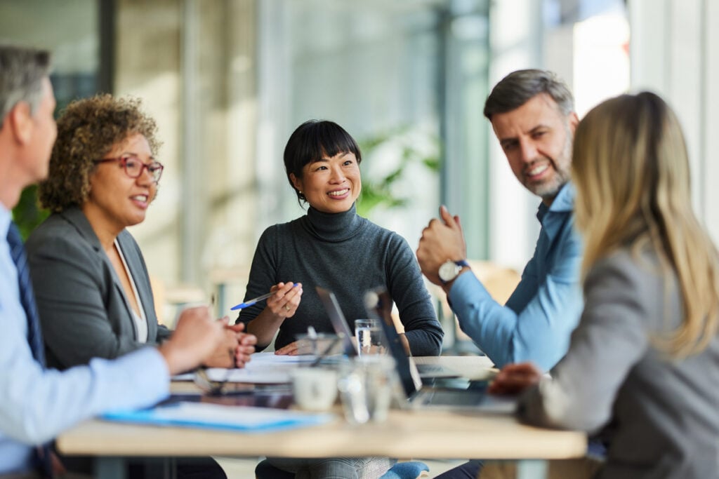 Diverse digital marketing company team members in a collaborative meeting, symbolizing strategic planning and partnership.