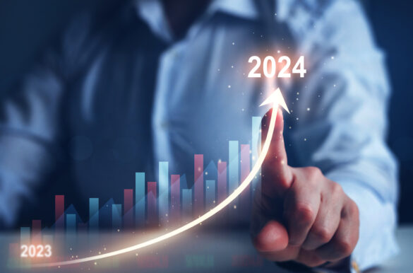 Man touching a digital screen with a bar graph, charting upwards from 2023 to 2024.