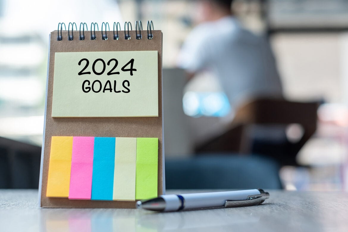 Notepad and pen with the notepad reading “2024 goals”
